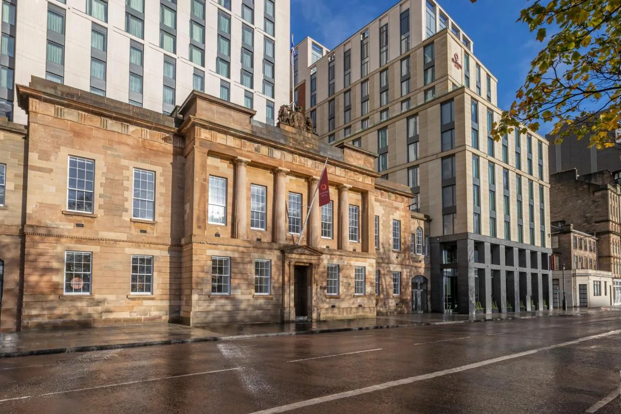 an old building in a city with tall buildings at Clayton Hotel Glasgow City in Glasgow