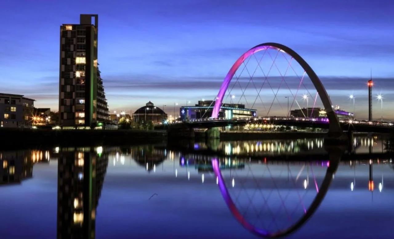 a bridge over a body of water at night at Clayton Hotel Glasgow City in Glasgow